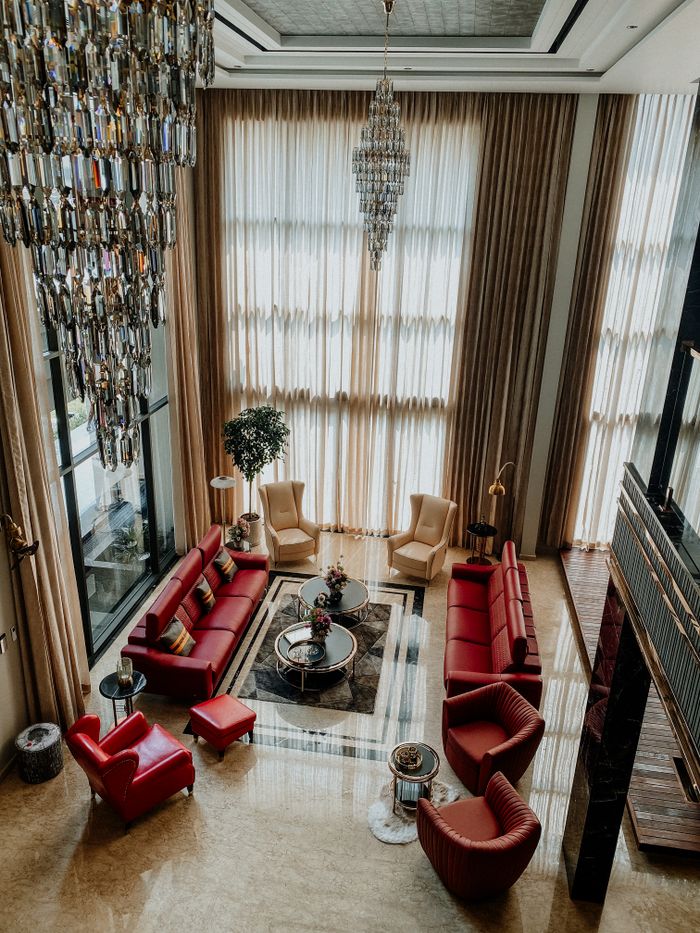 A lavish modern living area featuring chandeliers, luxurious seating, and elegant decor.